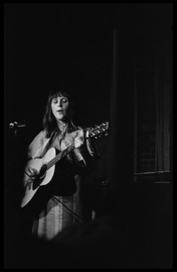 Woman acoustic guitarist performing on stage at the closing of Club 47