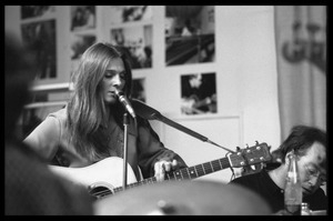 Judy Collins with guitar at the microphone, accompanied by Michael Sahl on piano