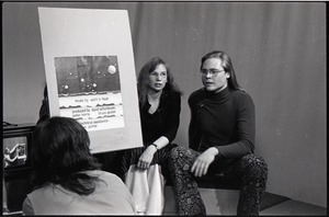 James Baker and Anne Baker seated on stage with placard containing credits for the WGBY program Open Door