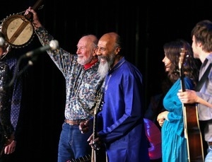 Pete Seeger hoisting his banjo and Richie Havens at the end of their set at the Clearwater Festival