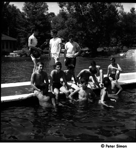 Camp Arcadia: campers at a swimming pool, one playing a guitar