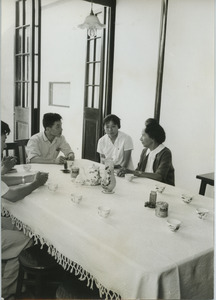 Shirley Graham Du Bois with two unidentified men and one woman having tea
