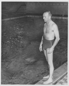 Joseph R. Rogers standing, speaking beside pool