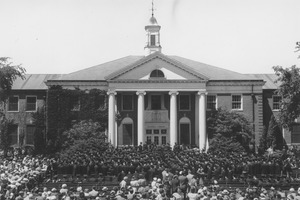 Commencement graduates and spectators in front of Goodell Library