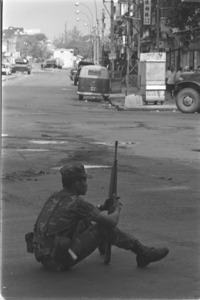 During lull, Vietnamese Ranger keeps watch on crossroad in Cholon; Saigon.