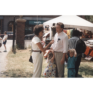 A man and woman converse at a park event