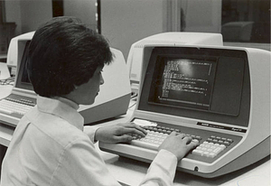 Woman tying on computer (c. 1990) - Digital Commonwealth