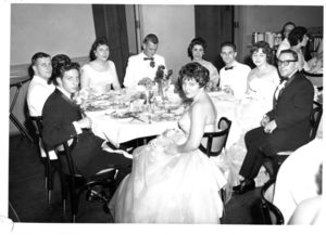 Suffolk University students sitting around table at the 1961 Senior Prom