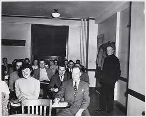 View of Father Ryan with students in classroom at Boston Evening College