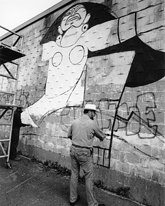 Artist Rafael Rivera Garcia painting mural at Perkins and Centre Street in Jamaica Plain