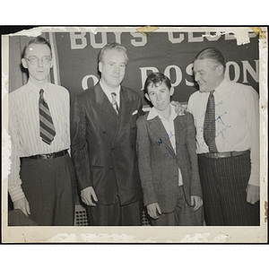 Former Boston Mayor John E. Kerrigan puts his arm around a boy [Joe O'Brien?] while Joseph P. Spang, Jr., Overseer of the Boys' Clubs of Boston, at far right, looks on