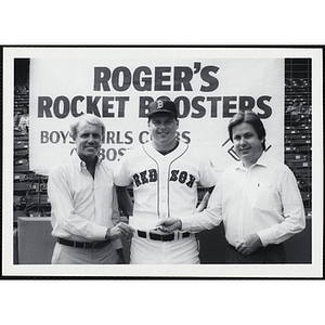Boston Red Sox Roger Clemens, center, posing with two unidentified men holding a donation check at "Roger's Rocket Boosters" event