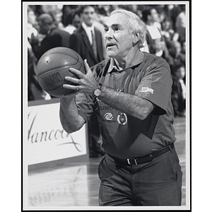 Sports attorney Bob Woolf holding a basketball and standing in shooting position at a fund-raising event held by the Boys and Girls Clubs of Boston and Boston Celtics