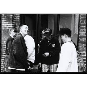 A group of teenage boys standing together outside the Charlestown Boys and Girls Club building