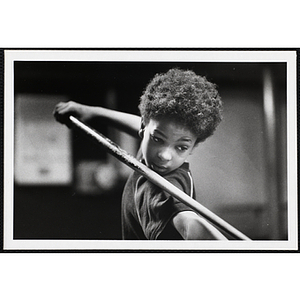 An African American boy from the Boys' Clubs of Boston preparing to shoot with a cue