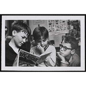 Three boys read "The Pop-Up Book of Left and Right"