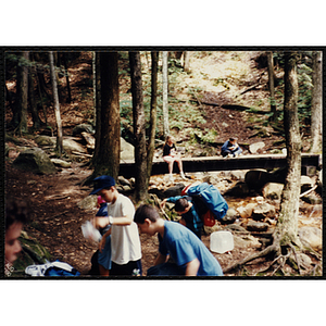 A group of youth gathered by a creek along the Piper Trail