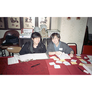 Two women at the welcome table during a celebration of the Lunar New Year hosted by the Chinese Progressive Association