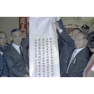 Henry Wong and a member of the delegation from Guangdong Province hold up a banner with Chinese inscription