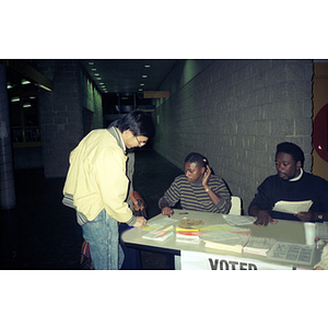 Men reviewing papers at a voter registration event