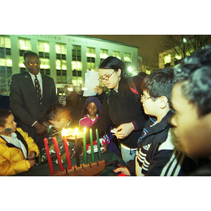 Lighting candles for Kwanzaa during a holiday celebration in Krentzman quadrangle