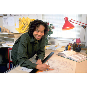 A young woman working on a draft at an architectural firm during her co-op experience