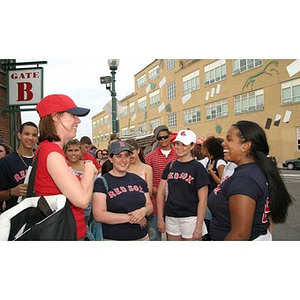 Advisor Meghan Eliason stands with a group of Torch Scholars outside Fenway Park