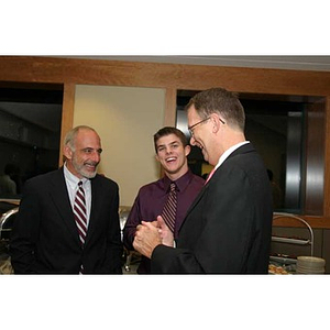 Joseph Bordieri laughs with two men at the Torch Scholars dinner