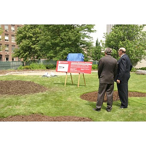 Two men look at the sign for the Veterans Memorial during the groundbreaking ceremony