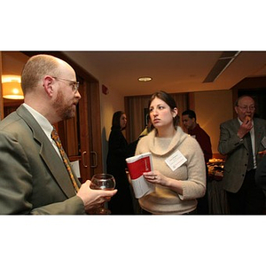 A woman and a man converse at a Torch Scholars event