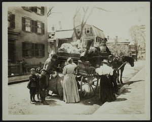 Group of people looking at a peddler's goods, possibly Somerville, Mass., 1895-1905