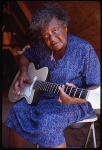 Older woman in tent playing an electric guitar, Resurrection City encampment