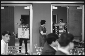 Protesters outside the Selective Service College Qualification examination to determine eligibility for an educational deferment from service in the Vietnam War: 'Taking the test says Let the dummies die.. in Vietnam'