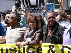 Al Sharpton, Susan Sarandon, and Roger Toussaint lined up behind a banner for Peace, Justice, and Democracy during the march against the war in Iraq