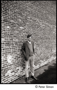 Howard Zinn: full-length portrait standing against a brick wall