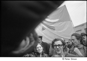 MIT war research demonstration: demonstrators raising their fists in front of the NLF flag