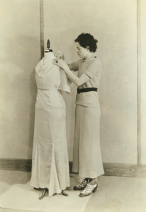 Unidentified woman draping a dress mannequin