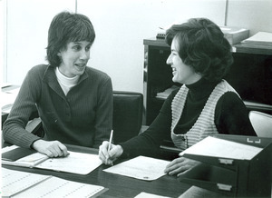 Ellen Wolf and Carol Dersham talking at desk