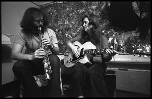 Bonnie Raitt backstage playing guitar, with John Payne (soprano saxophone)