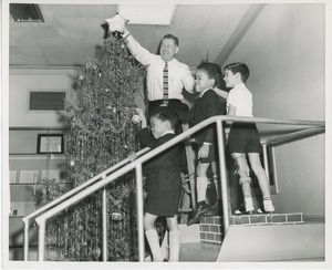 Willis C. Gorthy decorating Christmas tree with young clients