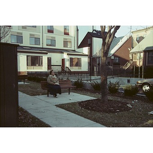 Woman on a park bench behind Taino Tower.