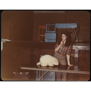 A woman standing at a table with an albino North American porcupine [?] during the Animal Show