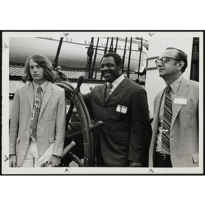 From left to right, Peter Wrenn, Jim Lee Hunt, and N.B. Gradone pose on the deck of a ship at a Boys' Clubs of Boston event