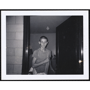 A teenage boy from the Charlestown Boys' Club standing at the door with a sports bag