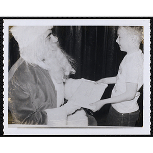 Santa Claus presents a gift to a boy
