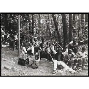 Youth eating a meal in the woods