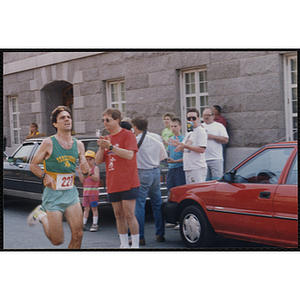 A man runs past cheering spectators during the Bunker Hill Road Race