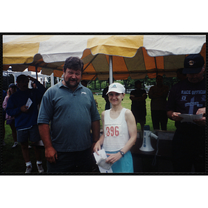 A woman and a man pose for a shot as Charlestown director Jerry Steimel (background, left) looks on during the Battle of Bunker Hill Road Race