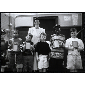 Heather Khan, a former news anchor, posing with six boys holding their awards at a Kiwanis Awards Night