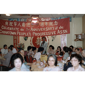 Man addresses a group at the Chinese Progressive Association's Third Anniversary Celebration